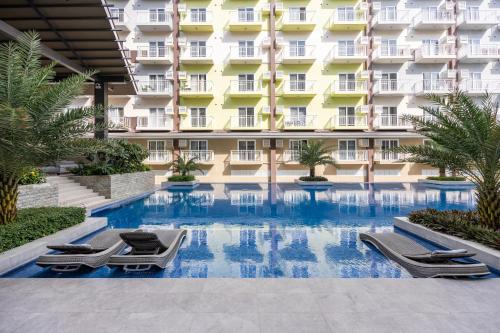 una piscina di fronte a un edificio di Stylish Condo Near Airport- Poolview Amani Grand a Mactan Cebu International