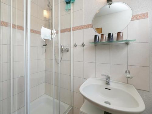 a bathroom with a sink and a shower and a mirror at Ferienhaus in Liebenscheid nahe Fuchskaute in Liebenscheid