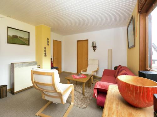 a living room with a red couch and chairs at Ferienhaus in Liebenscheid nahe Fuchskaute in Liebenscheid