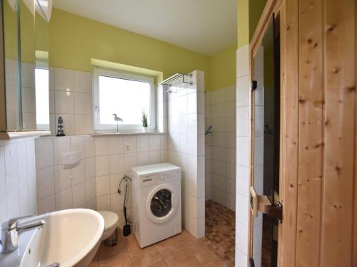 a bathroom with a washing machine and a sink at Komfortables Ferienhaus in Zierow mit Sauna in Zierow