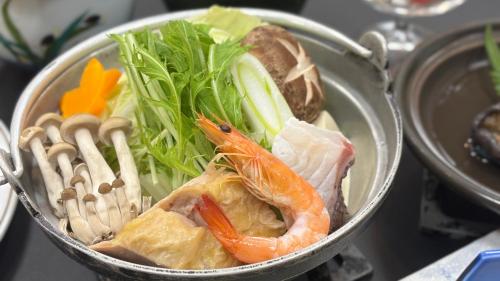 a bowl of food with seafood and vegetables in it at Ichinomata Onsen Kanko Hotel in Shimonoseki