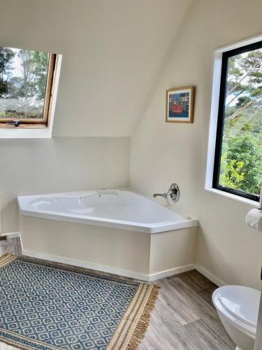 a white bath tub in a bathroom with a window at Coastal Sanctuary in Ngunguru