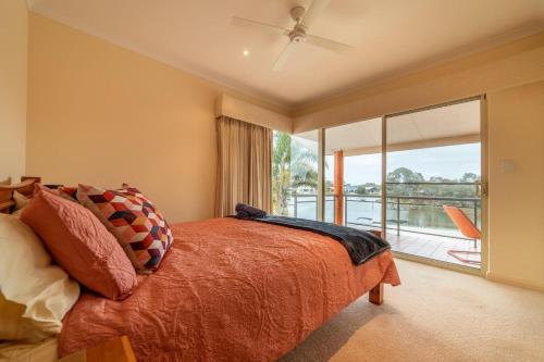 a bedroom with a bed and a large window at Funland, Family Home On The Canals Mandurah in South Yunderup