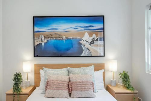 a bedroom with a bed with a picture on the wall at Heatherbrae Ii - Stunning Harbour Bridge Views! in Sydney
