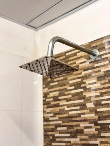 a shower head is attached to a brick wall at La Belle Homestay in Kandy