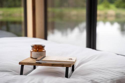 a table with a candle and a book on a bed at Banksia -designer Tiny Home W Stunning Dam Views in Kangaroo Valley