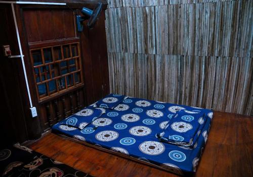 a bed in a room with a blue blanket at GoHaGiang in Ha Giang