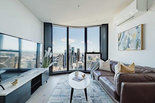 a living room with a couch and a table at Melbourne Modern CBD Stay Walk to Shops & Trams in Melbourne