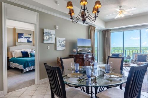 a dining room with a table and chairs and a bedroom at Two-Bedroom Apartment in Orange Beach