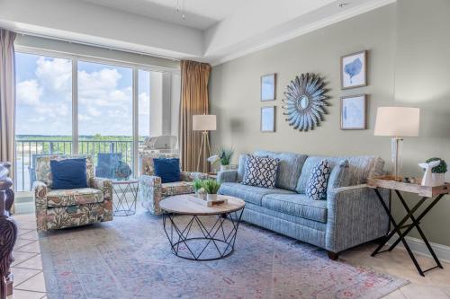 a living room with a blue couch and two chairs at Two-Bedroom Apartment in Orange Beach