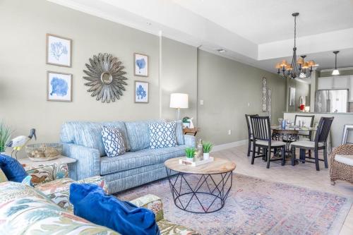 a living room with a blue couch and a dining room at Two-Bedroom Apartment in Orange Beach
