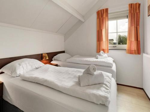 a bedroom with two beds and a window at Bungalow by Water with Sauna in South Holland in Simonshaven