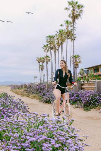 a woman riding a bike in a field of flowers at Luxe Ob Retreat Sauna, Bikes & Beach Nearby in San Diego