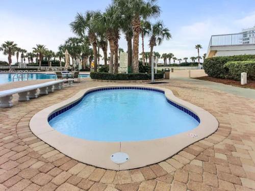 a large swimming pool with palm trees in the background at Silver Shells in Destin