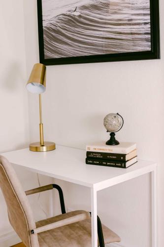a white desk with a lamp and books on it at Luxe Ob Retreat Sauna, Bikes & Beach Nearby in San Diego