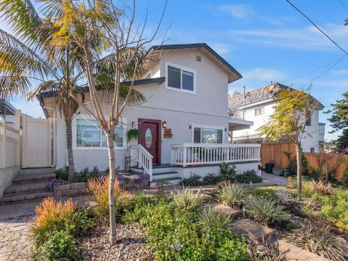 a white house with a palm tree in a yard at Luxe Ob Retreat Sauna, Bikes & Beach Nearby in San Diego