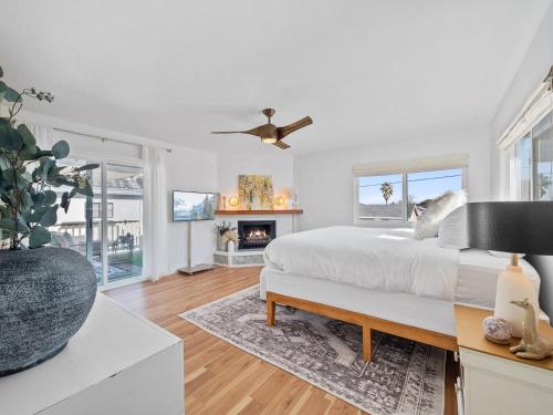 a white bedroom with a bed and a fireplace at Luxe Ob Retreat Sauna, Bikes & Beach Nearby in San Diego