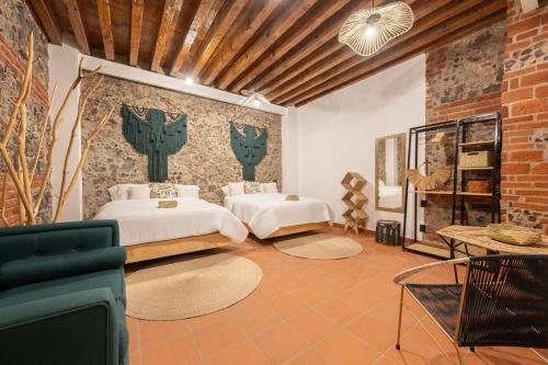 a bedroom with two beds and a brick wall at DH3 VIP & Luxurious 2beds APT in Historic Center in Mexico City