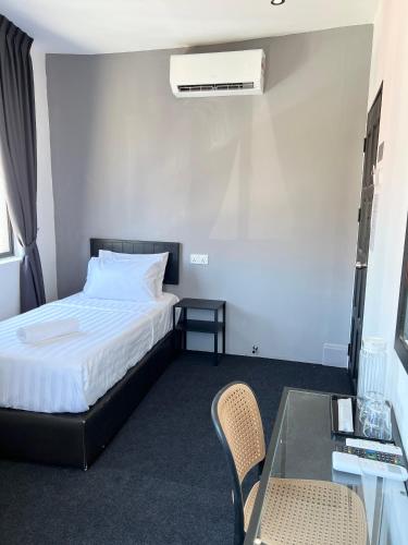 a bedroom with a bed and a table and chairs at Quee Hotel in George Town