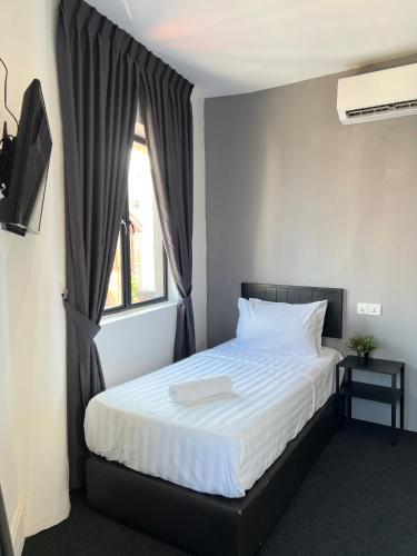 a bedroom with a large bed with a window at Quee Hotel in George Town