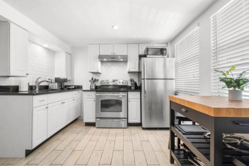 a kitchen with white cabinets and stainless steel appliances at Little Hyde Out - Updated Hyde Park 1st Floor Apartment in Tampa