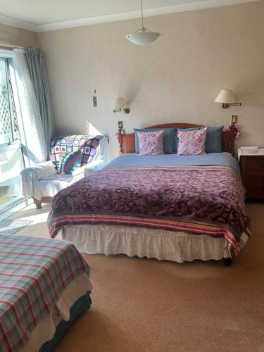 a bedroom with a large bed and a couch at Tamaterau Seaview House in Whangarei in Whangarei