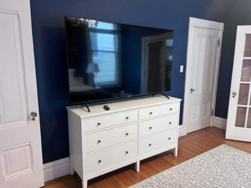 a white dresser with a television on top of it at Gorgeous Victorian Flat in San Francisco