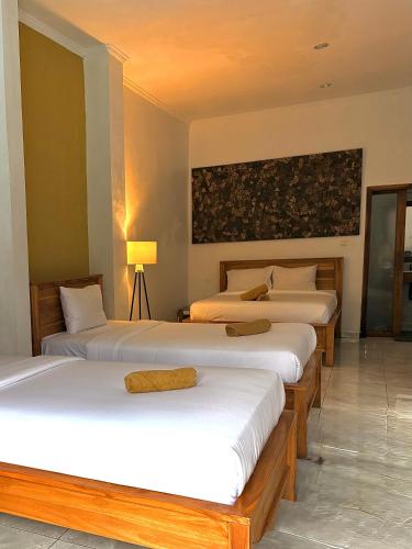 a room with three beds in a room at Medewi Beach Inn in Pulukan