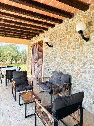 a patio with furniture and a stone wall at villa Diamante in Lamporecchio