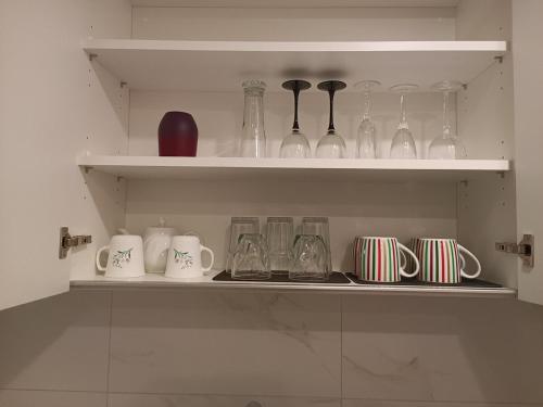 a shelf filled with glasses and other glass items at New condo Great amenities Near Skytrain in Coquitlam