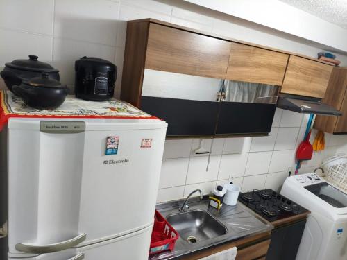 a small kitchen with a sink and a refrigerator at Aconchegante apto na Z Oeste in Sao Paulo