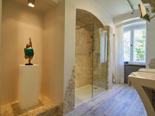 a bathroom with a shower and a statue of a woman at Villa Silva in Uslar