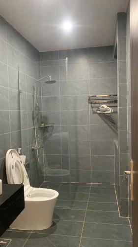 a bathroom with a toilet and a glass shower at An Nhien Serenity in B'su M'rac