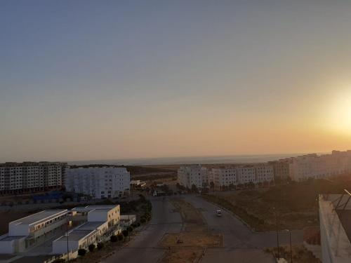 タンジェにあるAppartement neuf, lumineux et calme, entièrement meubléの建物と夕日が見える街の通りの景色