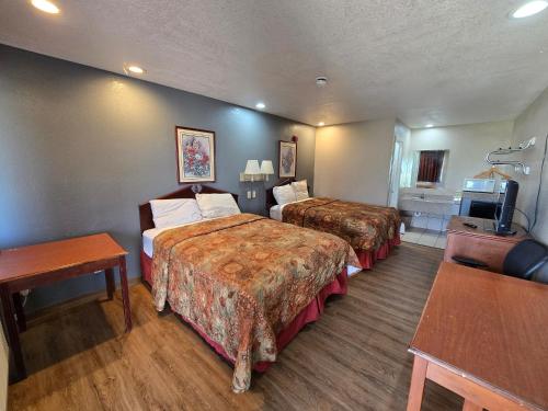 a hotel room with two beds and a television at Executive Inn in Fort Worth