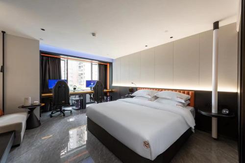 a bedroom with a large white bed and a desk at Leshan Shengman Hotel in Leshan