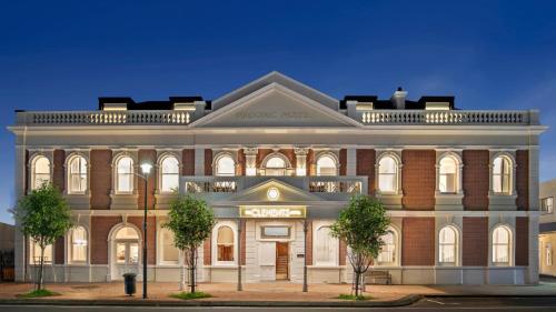 a large brick building with trees in front of it at The Clements Hotel in Cambridge