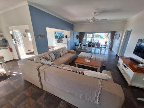 a living room with a couch and a tv at Seagulls Beach House in Port Shepstone