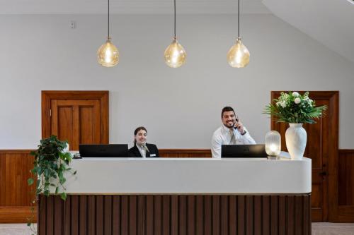 two men sitting at a desk with their laptops at The Clements Hotel in Cambridge
