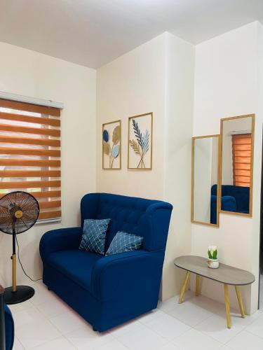 a blue couch in a living room with a table at Richviel Transient House Lucena City Unit1 in Lucena