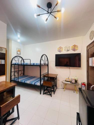 a room with two bunk beds and a flat screen tv at Richviel Transient House Lucena City Unit1 in Lucena