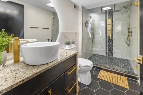a bathroom with a tub and a toilet and a shower at Modern Flat off Meridian - Walk Anywhere Downtown in Indianapolis