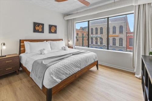 a bedroom with a bed and a large window at Modern Flat off Meridian - Walk Anywhere Downtown in Indianapolis