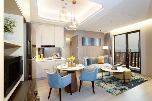 a living room with a couch and a table and chairs at Somerset Queen City Semarang in Stasiun Tawang