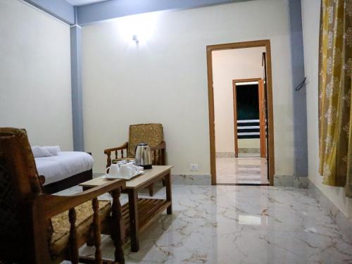 a living room with a bed and a table and chairs at Ess-PHLYNDA in Lāitlyngkot