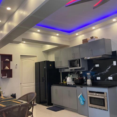 a kitchen with a blue light on the ceiling at Deluxe 2 Bedroom Condo Royal Oceancrest Mactan in Mactan Island