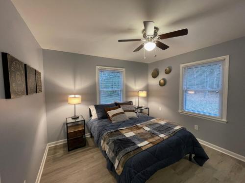 una camera da letto con un letto e un ventilatore a soffitto di Remodeled Cottage With Sunroom a Manchester