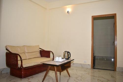 a living room with a chair and a coffee table at Ess-PHLYNDA in Lāitlyngkot