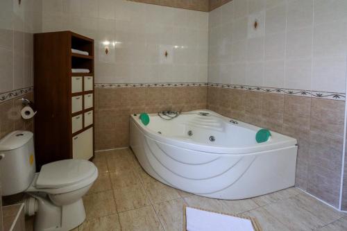 a bathroom with a white tub and a toilet at Hotel Roberto Sinaia in Sinaia
