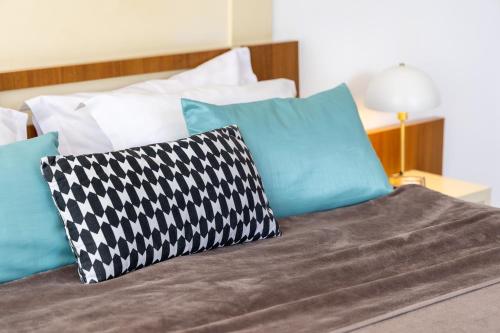 a bed with pillows on it with at Hotel Roberto Sinaia in Sinaia